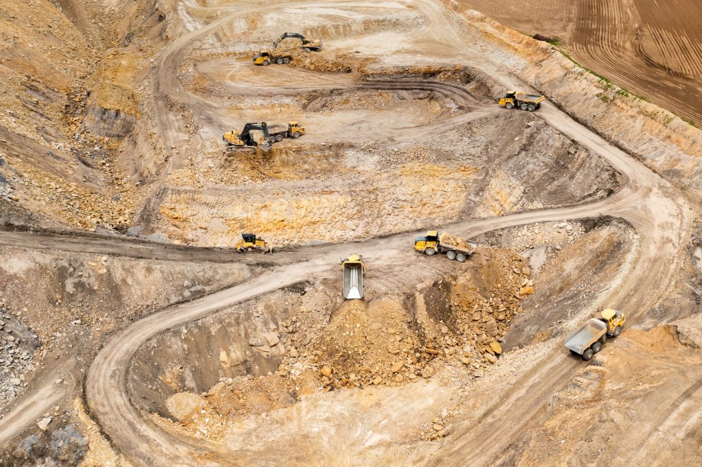 Aerial view of excavators digging ground. Opencast mining quarry