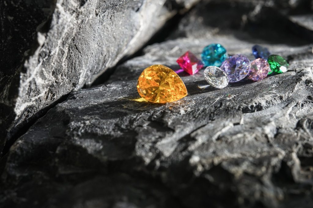Glimmering natural colorful sapphire gemstones on a rugged rock surface