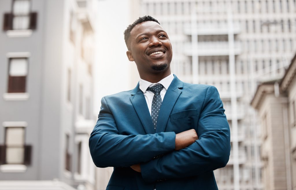 This city is mine for the taking. Shot of a handsome young businessman day dreaming.